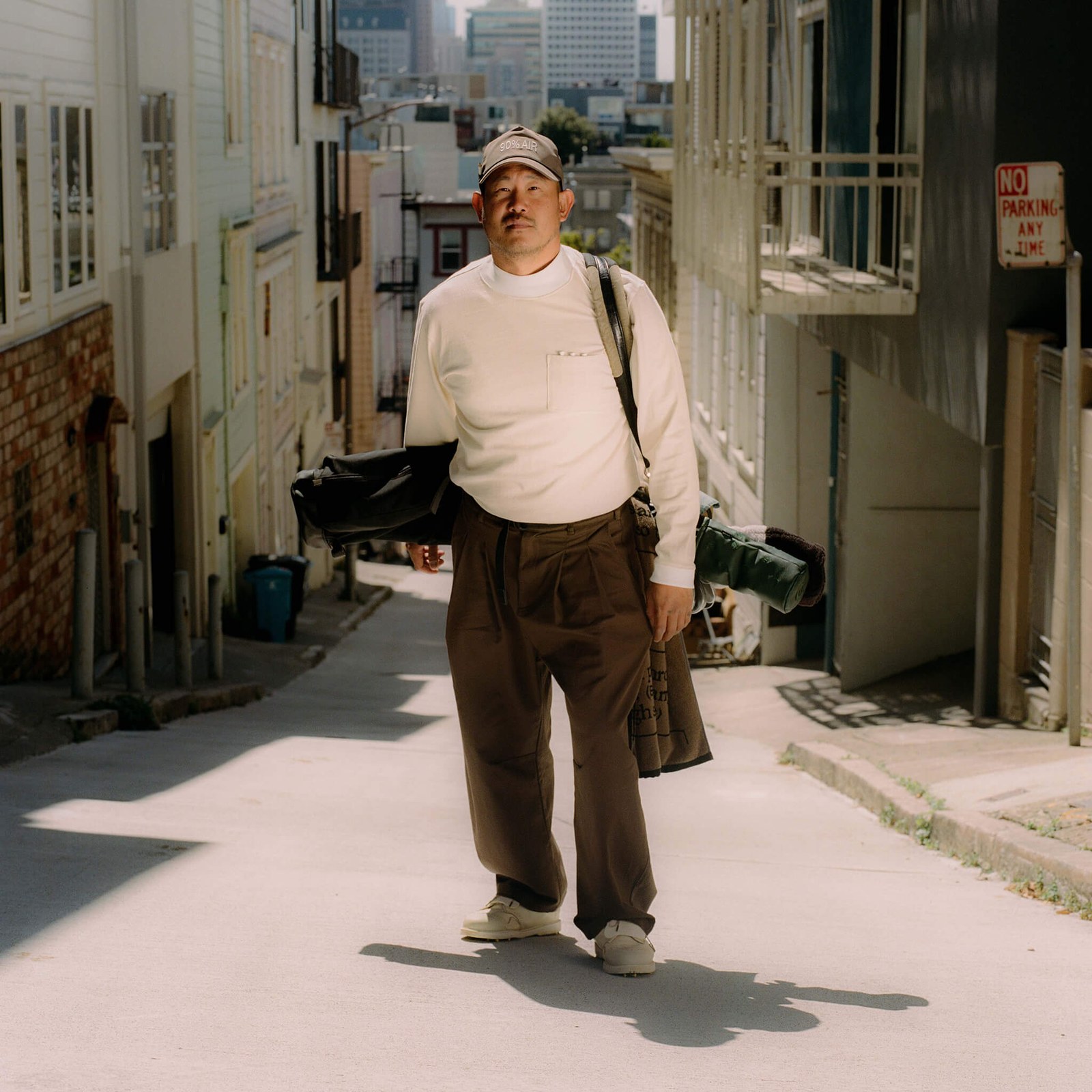The Work Shirt worn walking a city alley with a golf bag