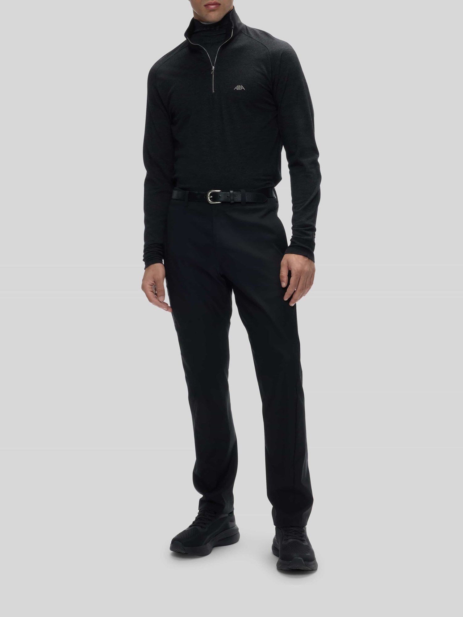 The Alba Grian quarter-zip polo worn full length with trousers