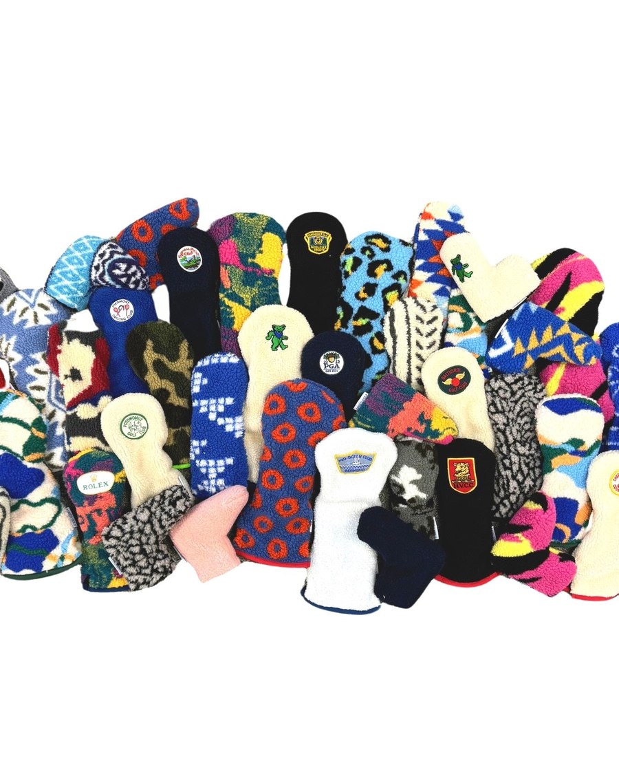 Dozens of Apr&egrave;s headcovers piled together, showing the range of patches and prints