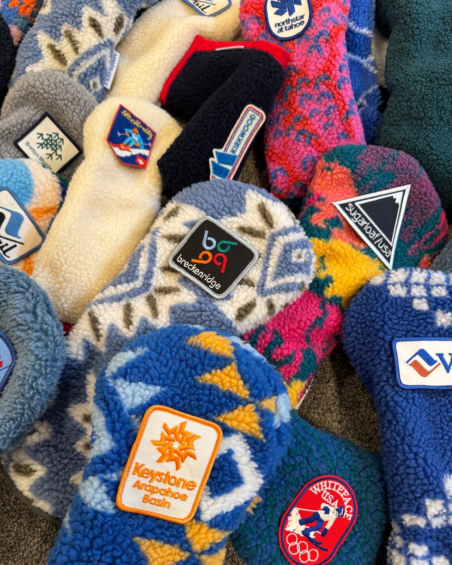 A pile of finished vintage-patch headcovers with the resort and club patches still tagged