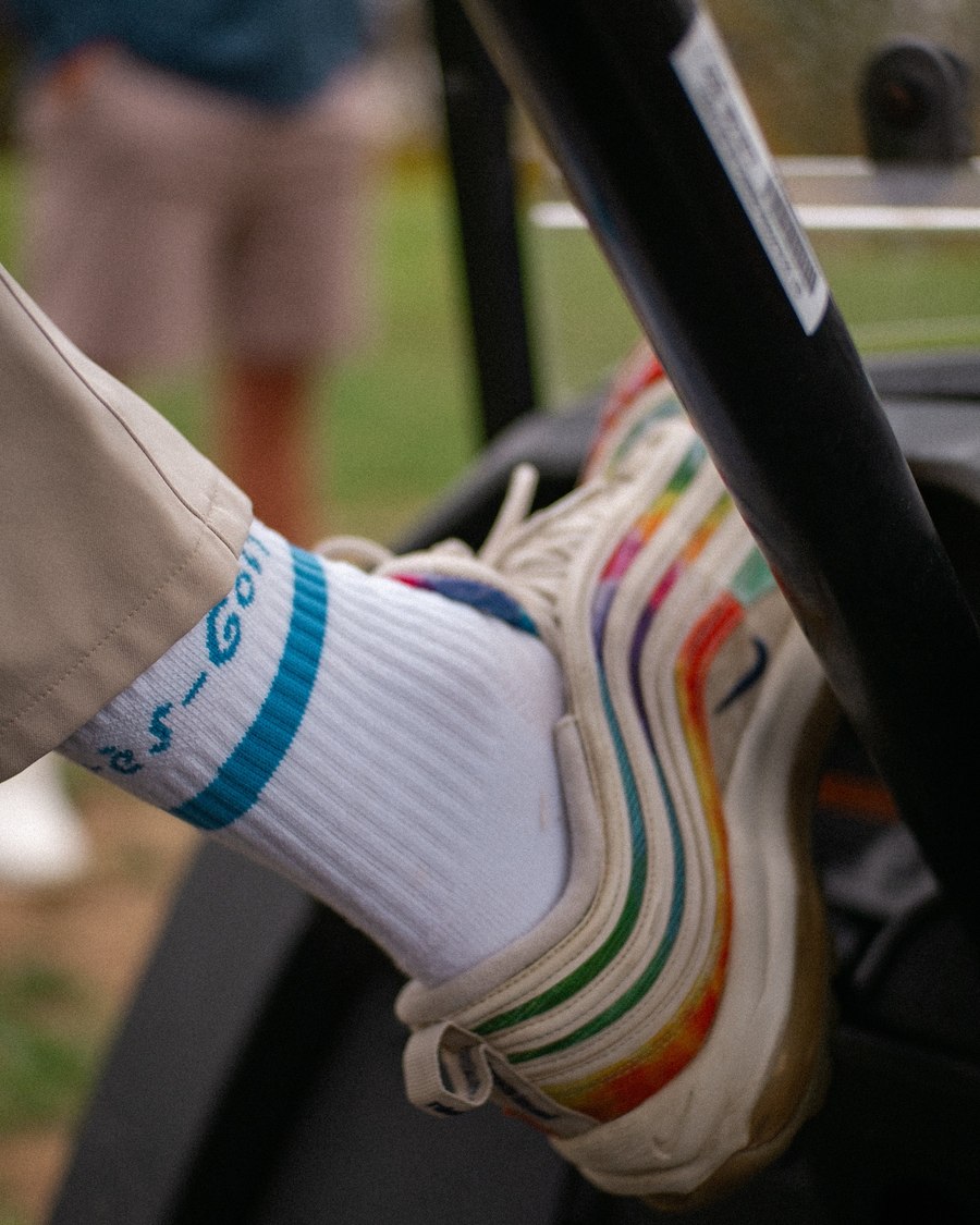 An Apr&egrave;s-Golf logo sock and a fleece cover at the foot of a push cart
