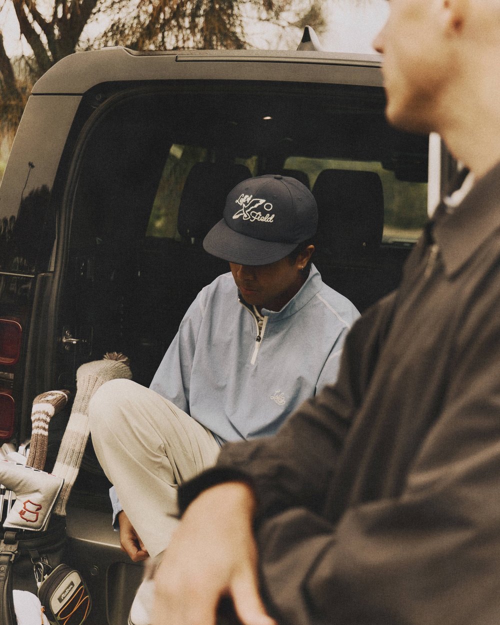 Left of Field campaign image: Pleats and a cap