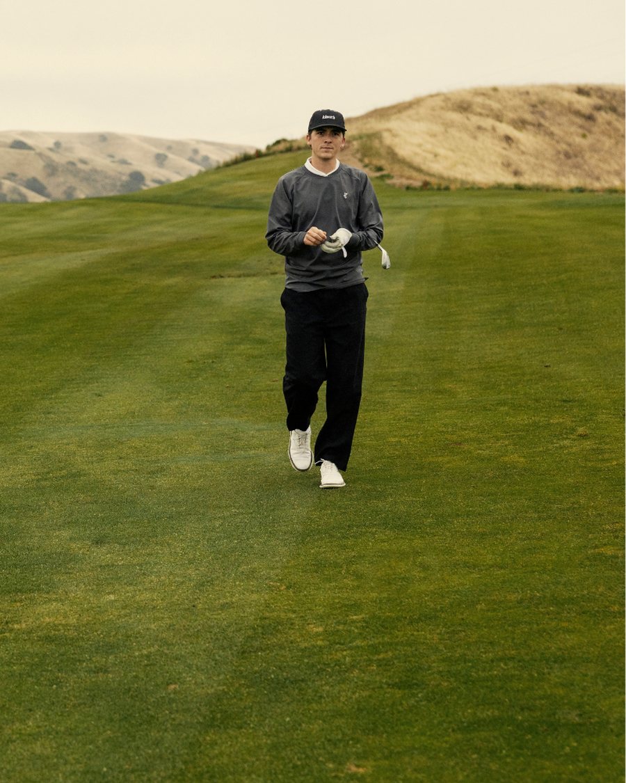 A golfer in Ashworth walking down a fairway