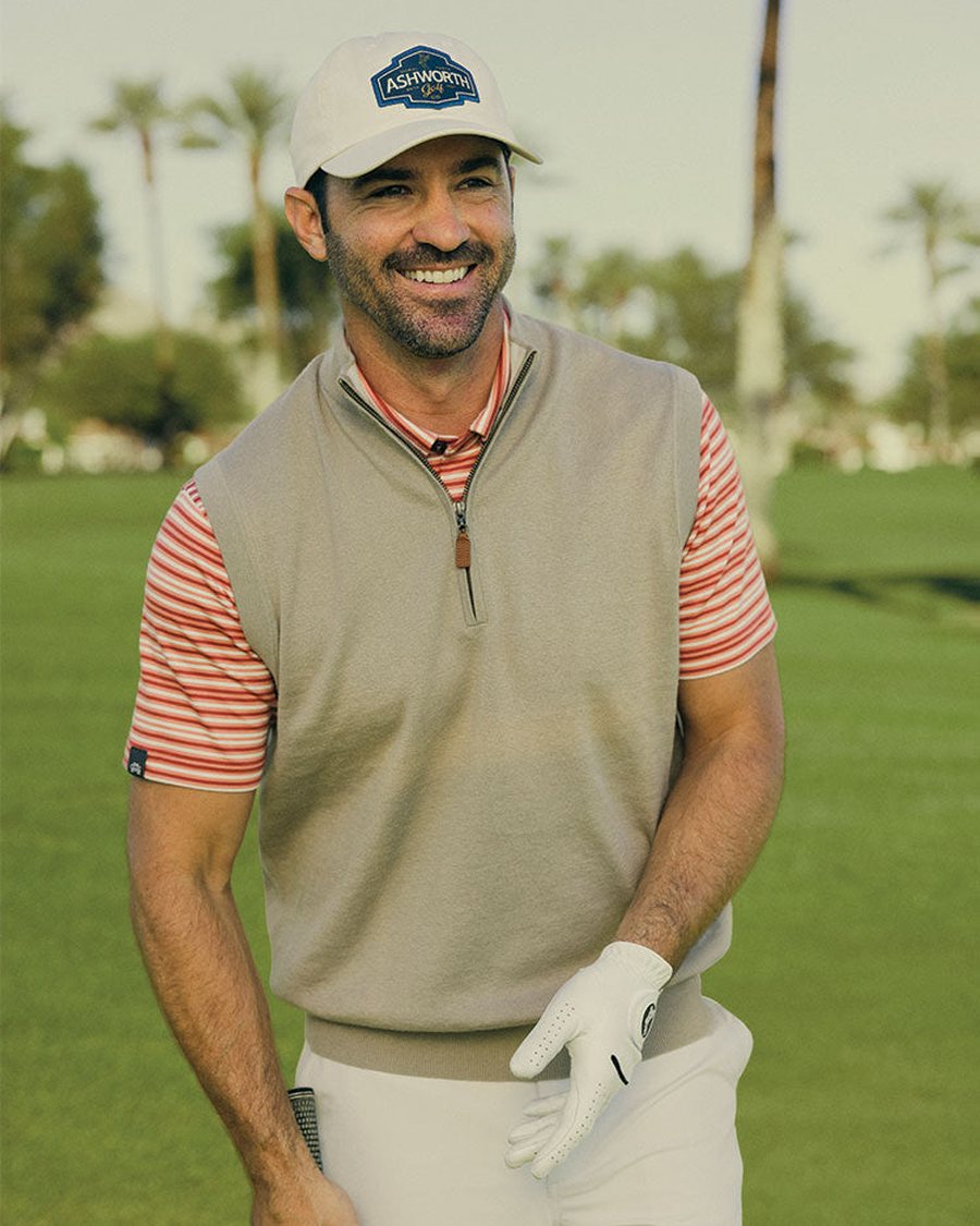 A golfer in an Ashworth sweater vest over a striped polo