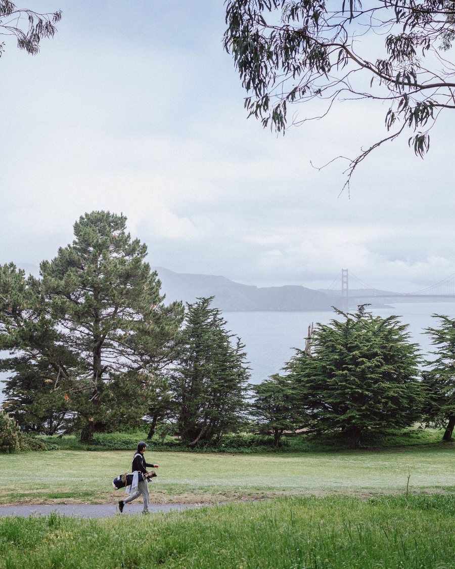 A golfer walking with his bag above the bay