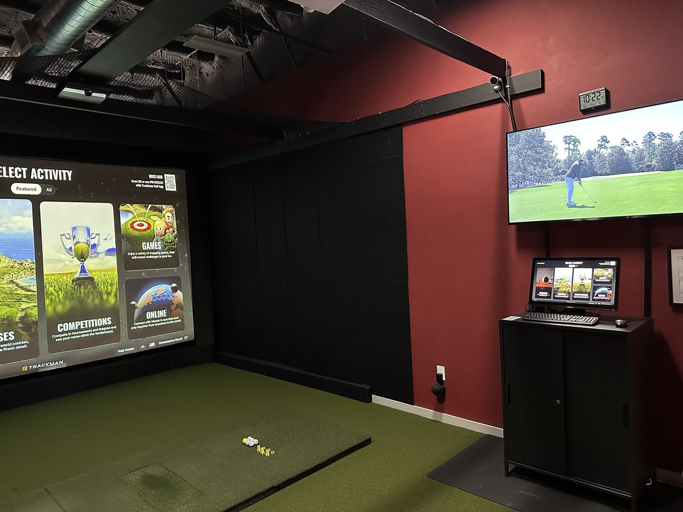 A private bay at ATX Indoor Golf Club with a wall-mounted TV