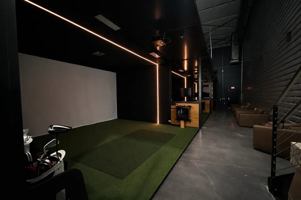 The darkened lounge and bay corridor inside Man Cave Golf Club