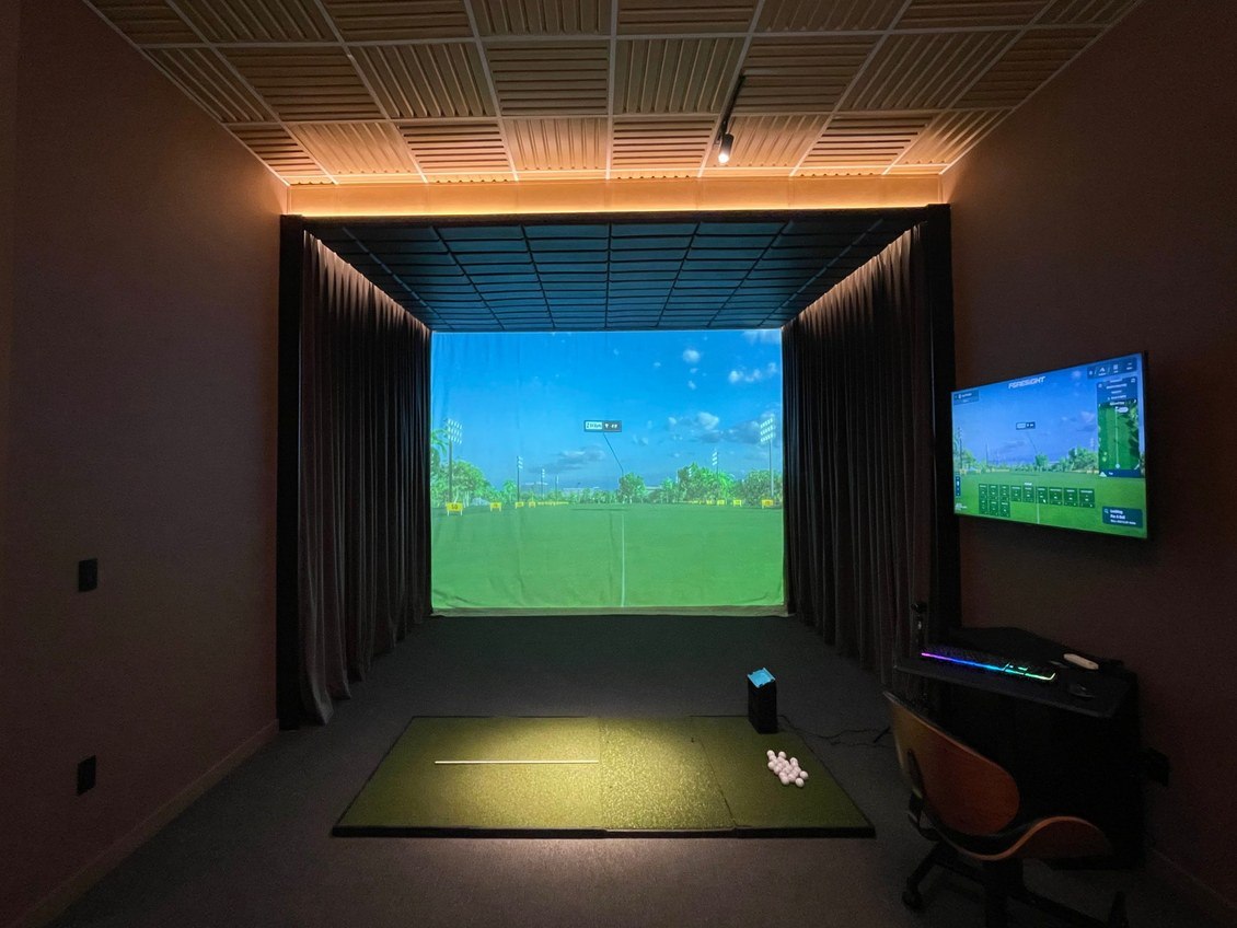 A darkened practice bay and screen at Dr. Golf Studio
