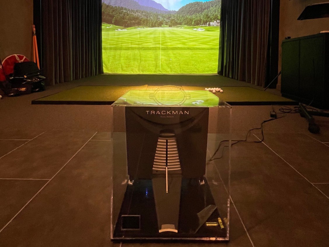 A TrackMan unit positioned on the floor of a bay at Dr. Golf Studio