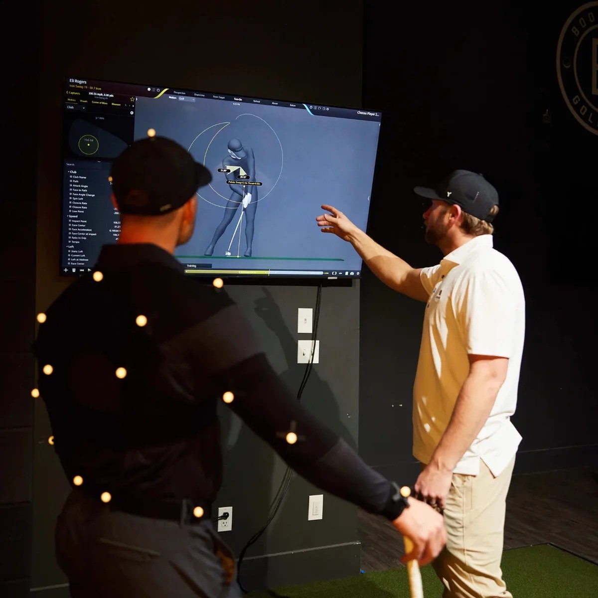 A coach reviewing swing data with a golfer at ROK Golf