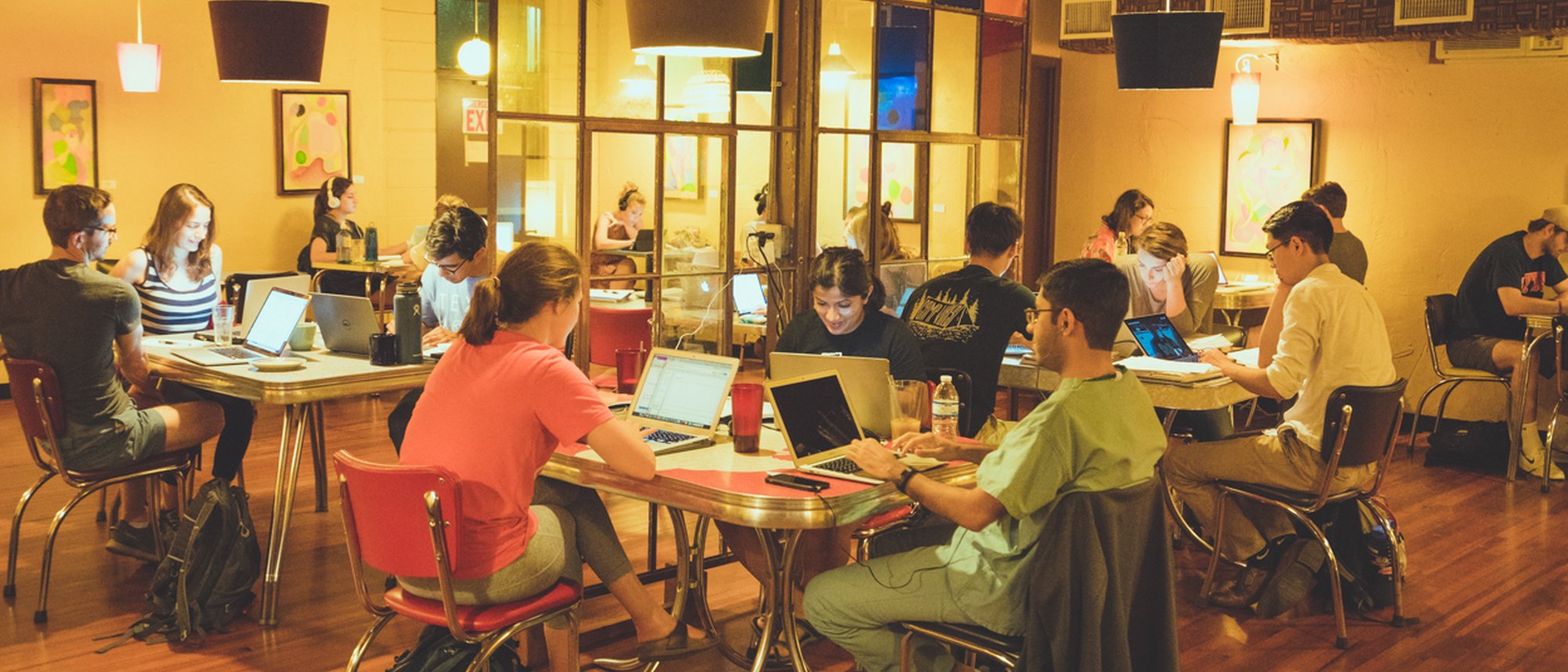 People working on laptops at big tables inside Flightpath Coffeehouse in Hyde Park