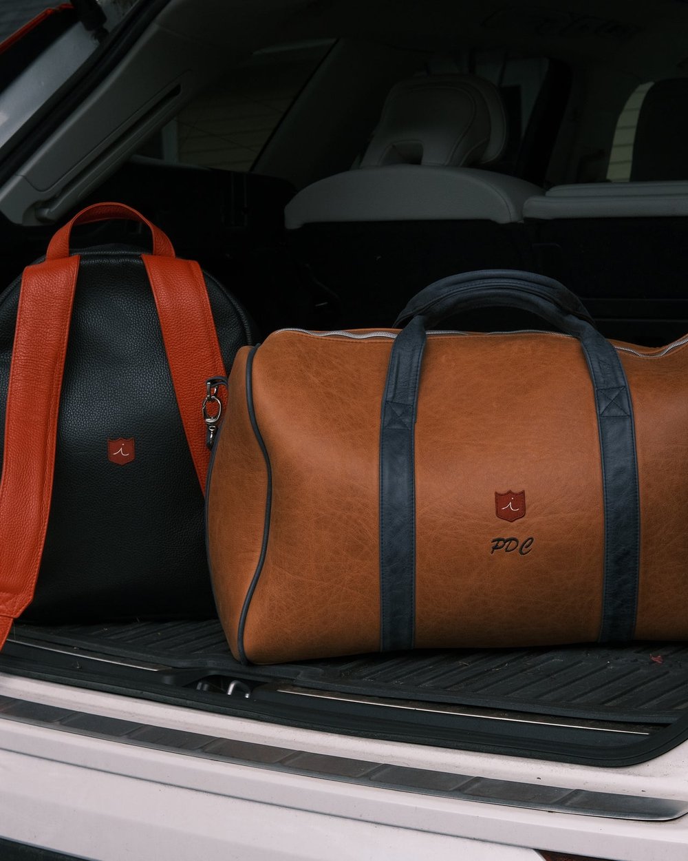 Two leather iliac bags in the boot of a car