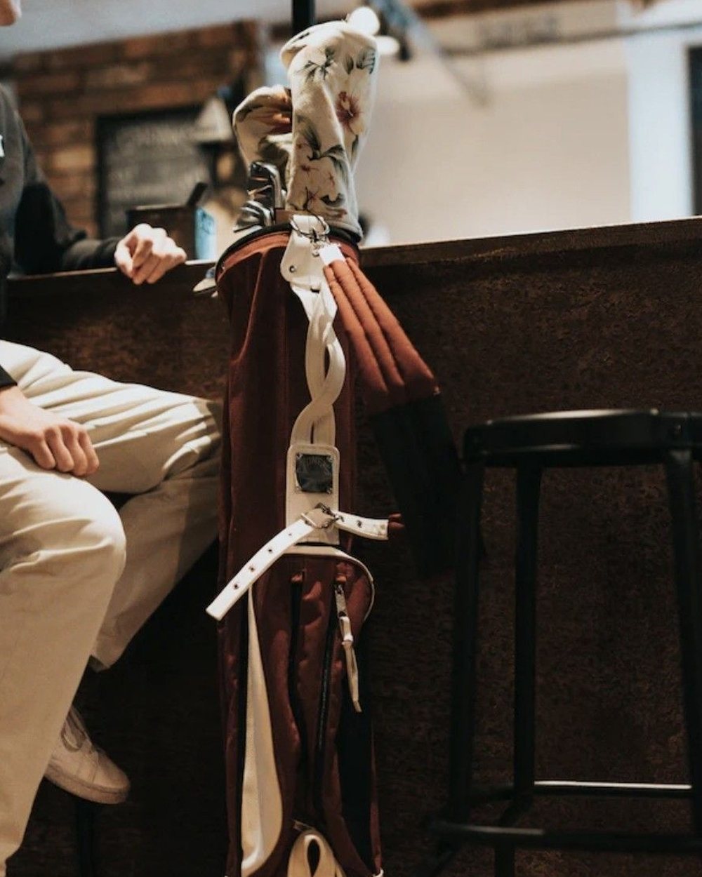 Via Pinterest photograph: A burgundy and white carry bag with a floral headcover at a bar