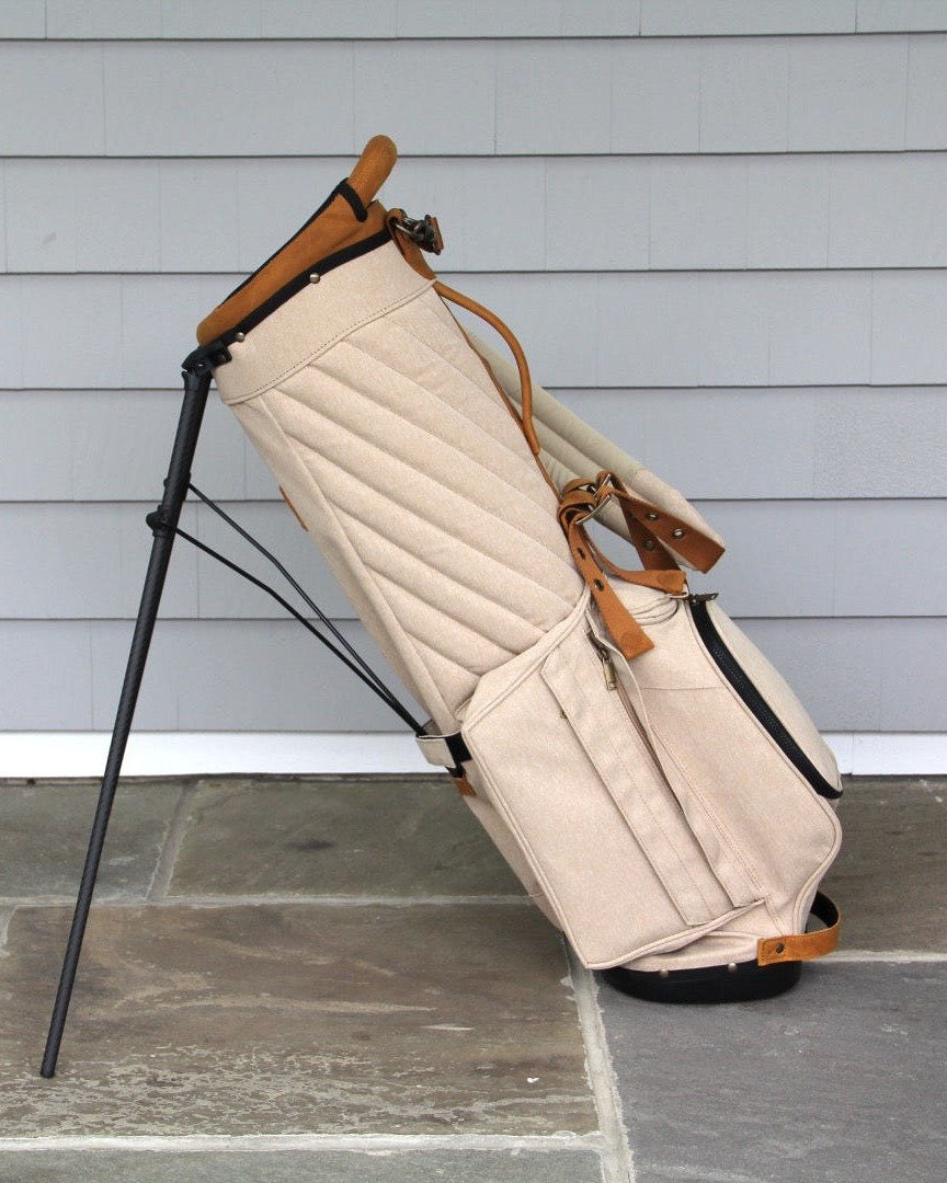 The Shapland Kantle 3.1 stand bag in cream, legs out on a stone path