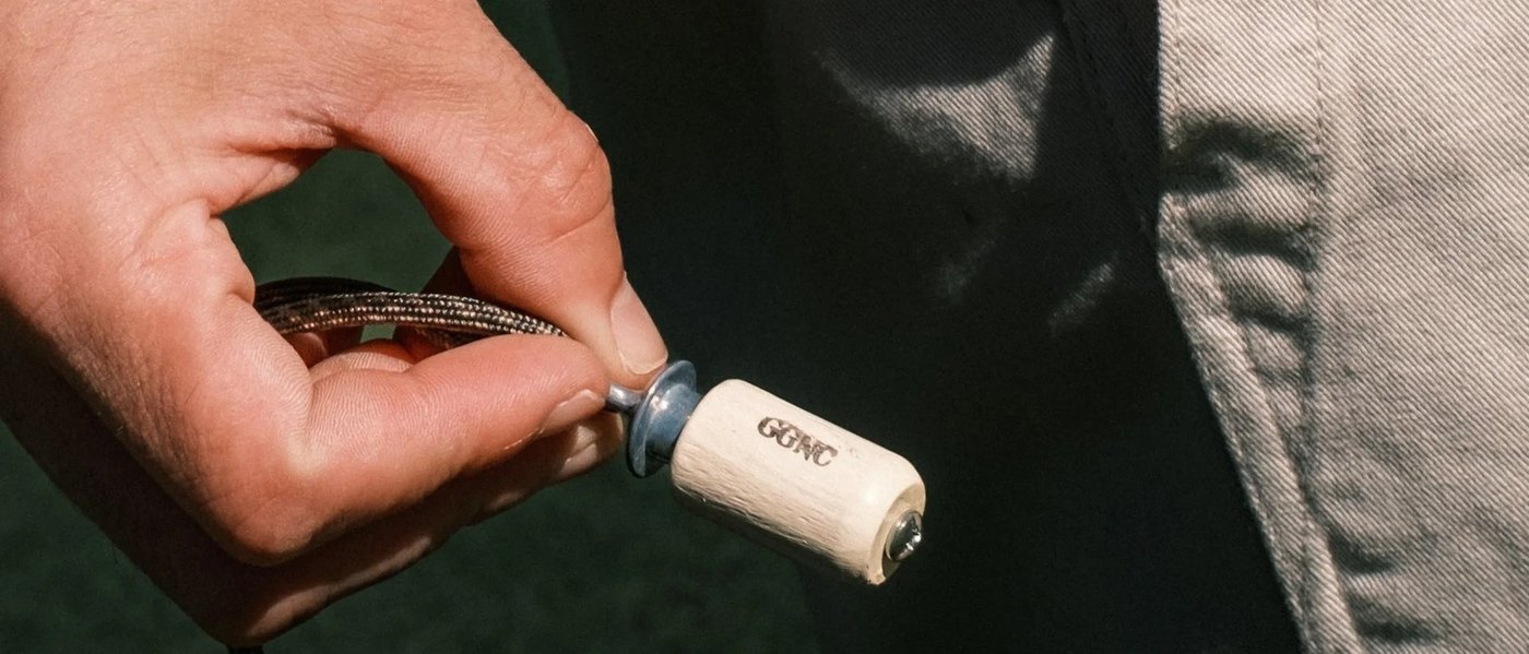 A hand working a Gumtree Golf & Nature Club wooden bird call over a green
