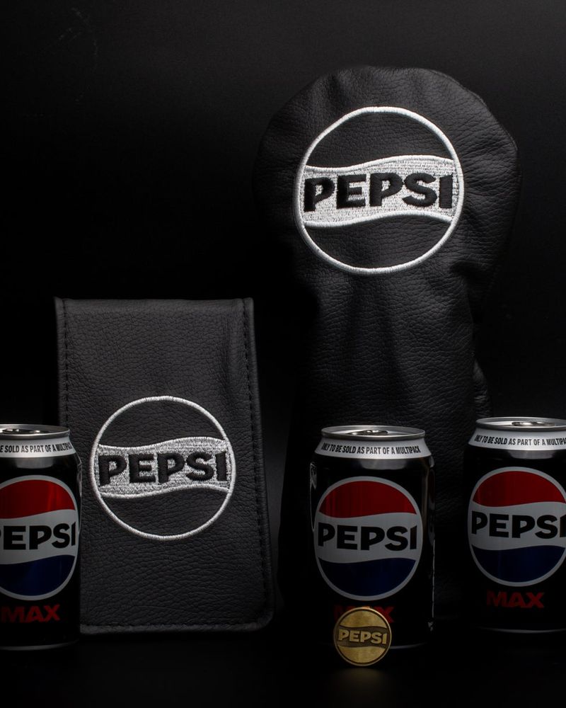Black Pepsi headcovers made by Clamp beside Pepsi cans