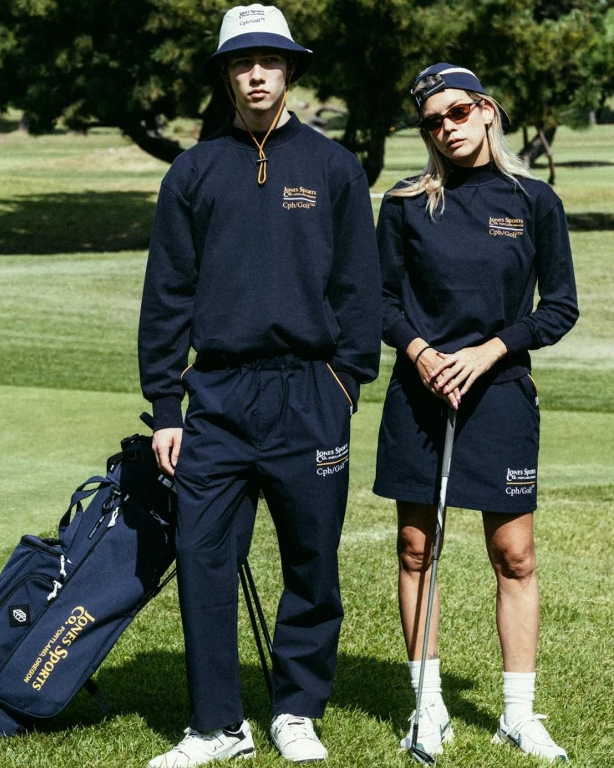 Two players in navy on a green with a Jones bag, from Cph/Golf&rsquo;s lookbook for the Jones collaboration