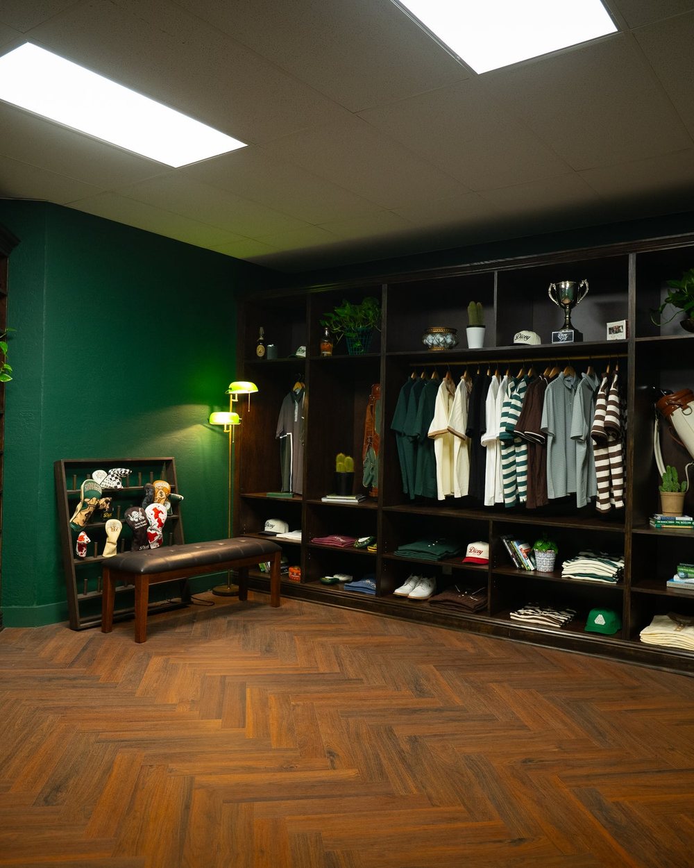 The Dicey Golf HQ pro shop with wood shelves, a green wall and racks of polos