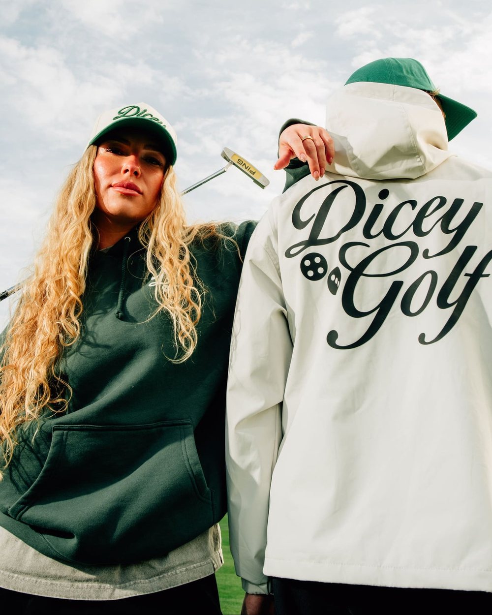 Two people on a desert course, one in a cream jacket with Dicey Golf across the back
