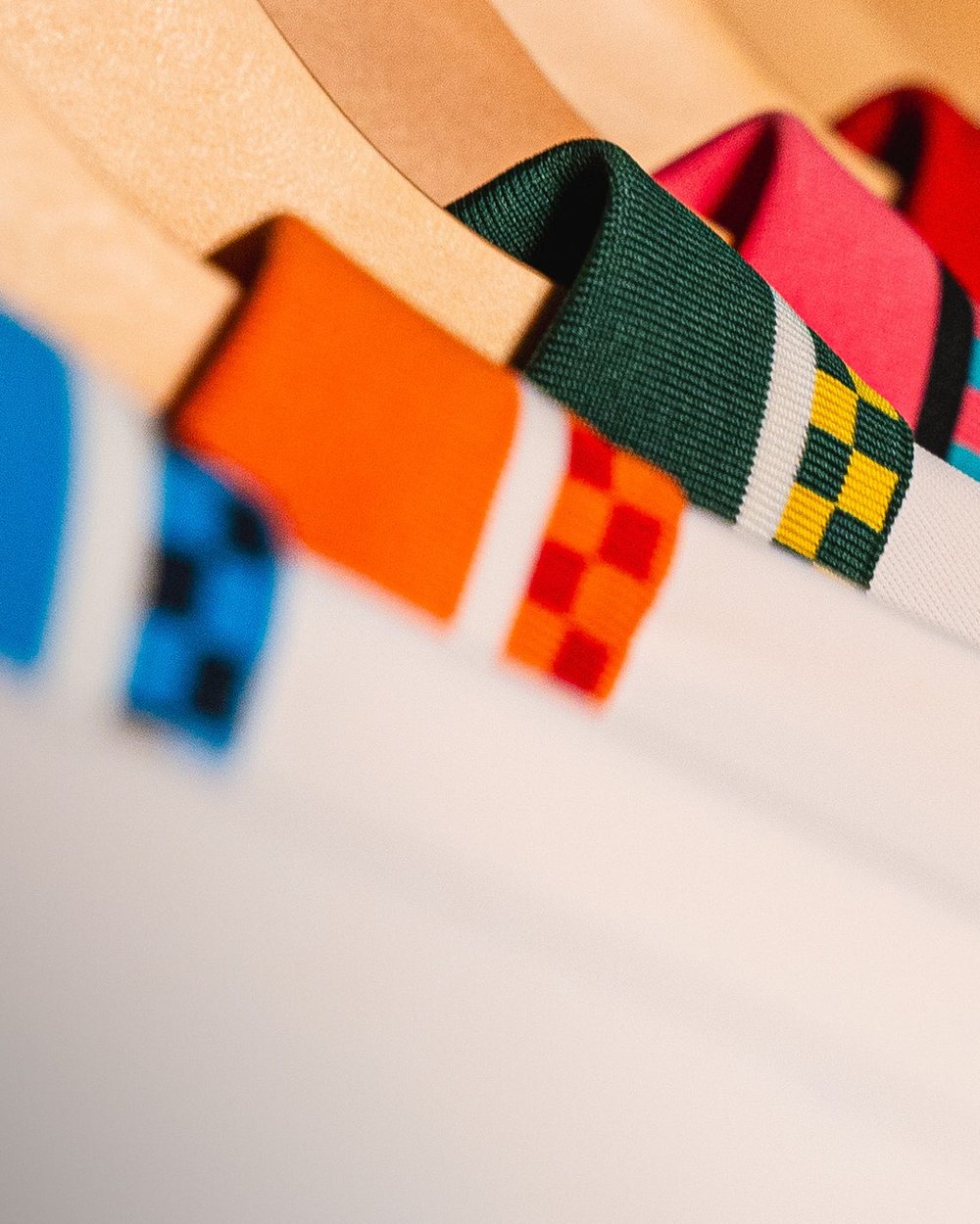Rows of Draft Day polos on hangers showing their colored collars