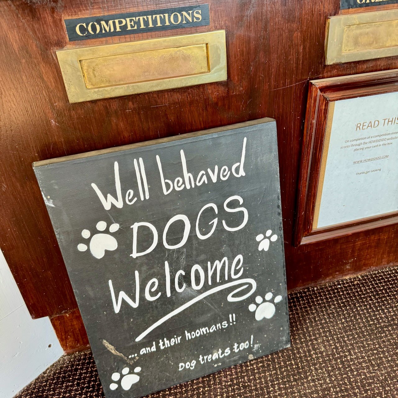 A chalkboard sign at a golf club reading Well behaved dogs welcome