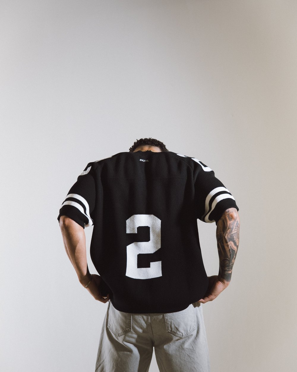 A man seen from behind in the black Classic Knit Jersey with a big 2 on the back