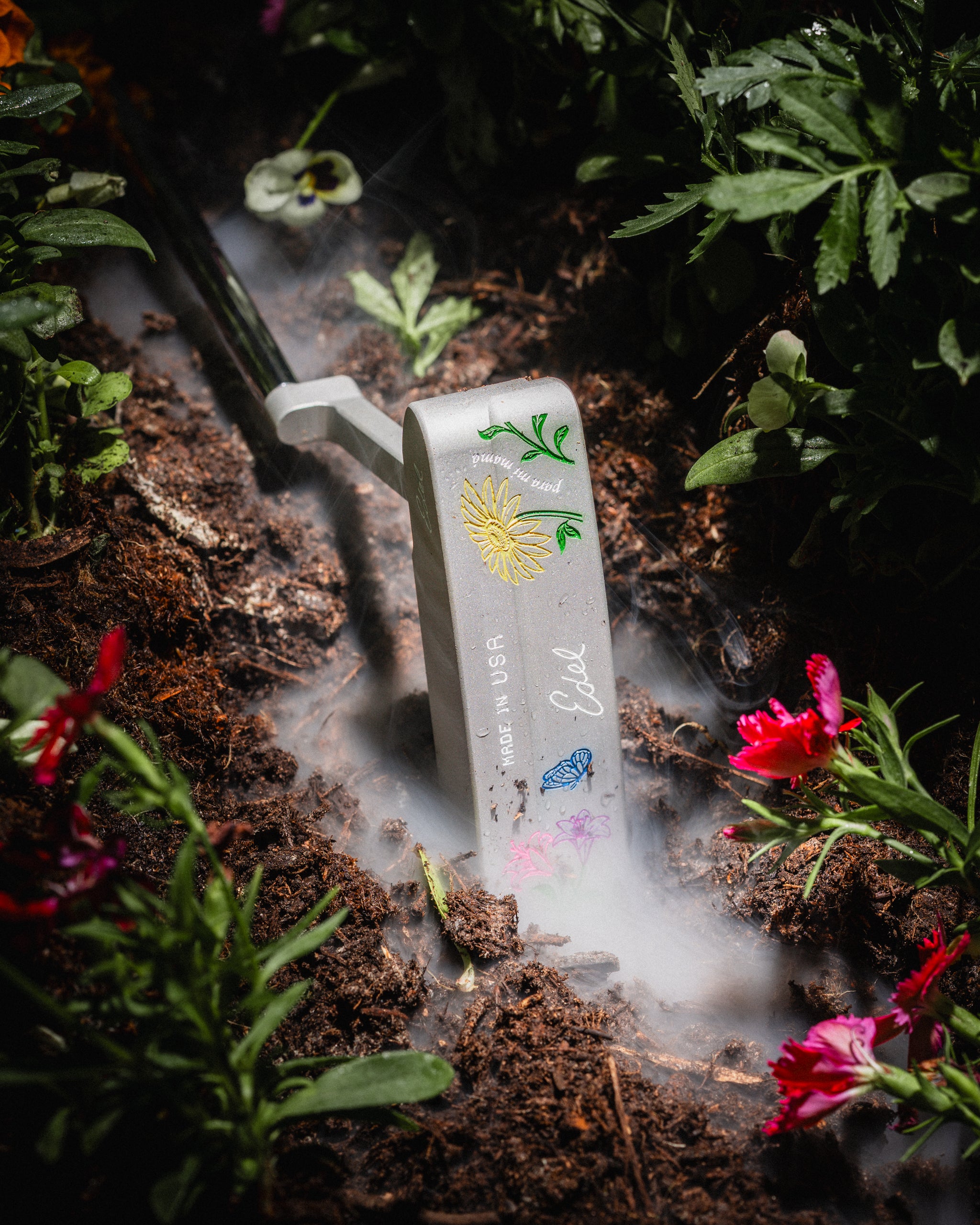 The Edel Bloom putter in a flowerbed under drifting smoke