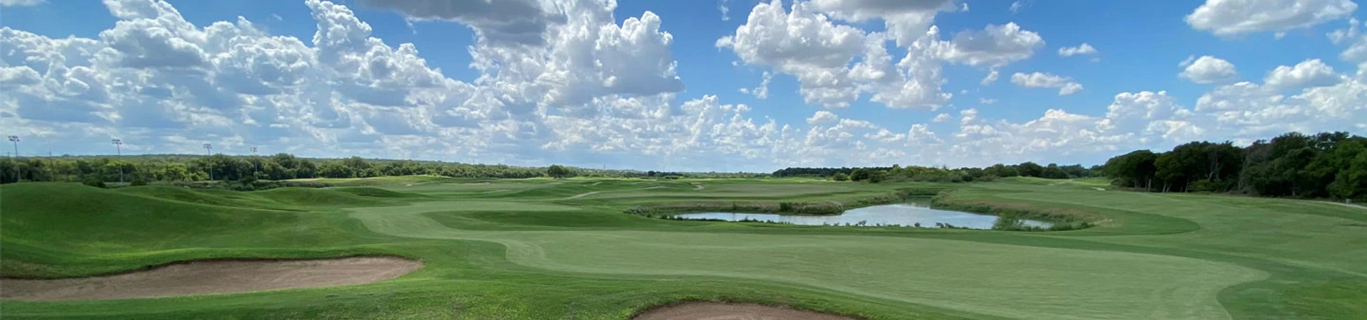 Panoramic view of links-style fairways, bunkers, and water at Roy Kizer Golf Course