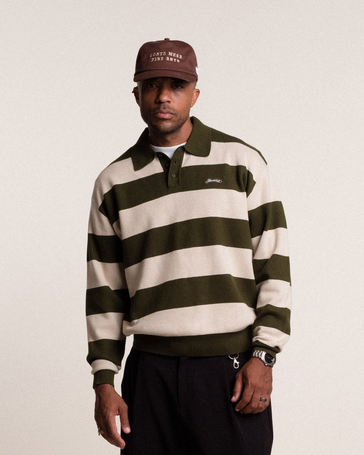 A man in the green and cream striped Whittier knit polo sweater