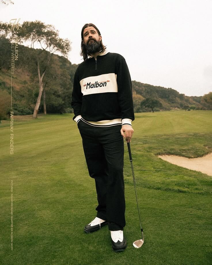 Malbon Golf editorial with golfer in all black holding iron on course