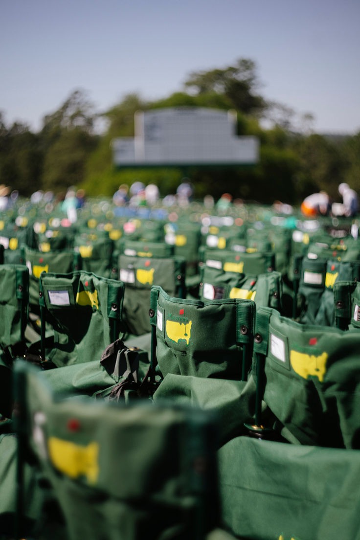 Rows of folded green caddie bibs stacked and numbered before a tournament