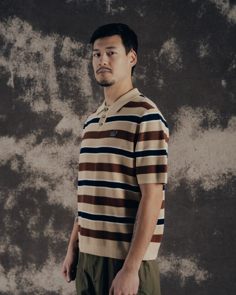 A model in the toffee-stripe Jake knit polo