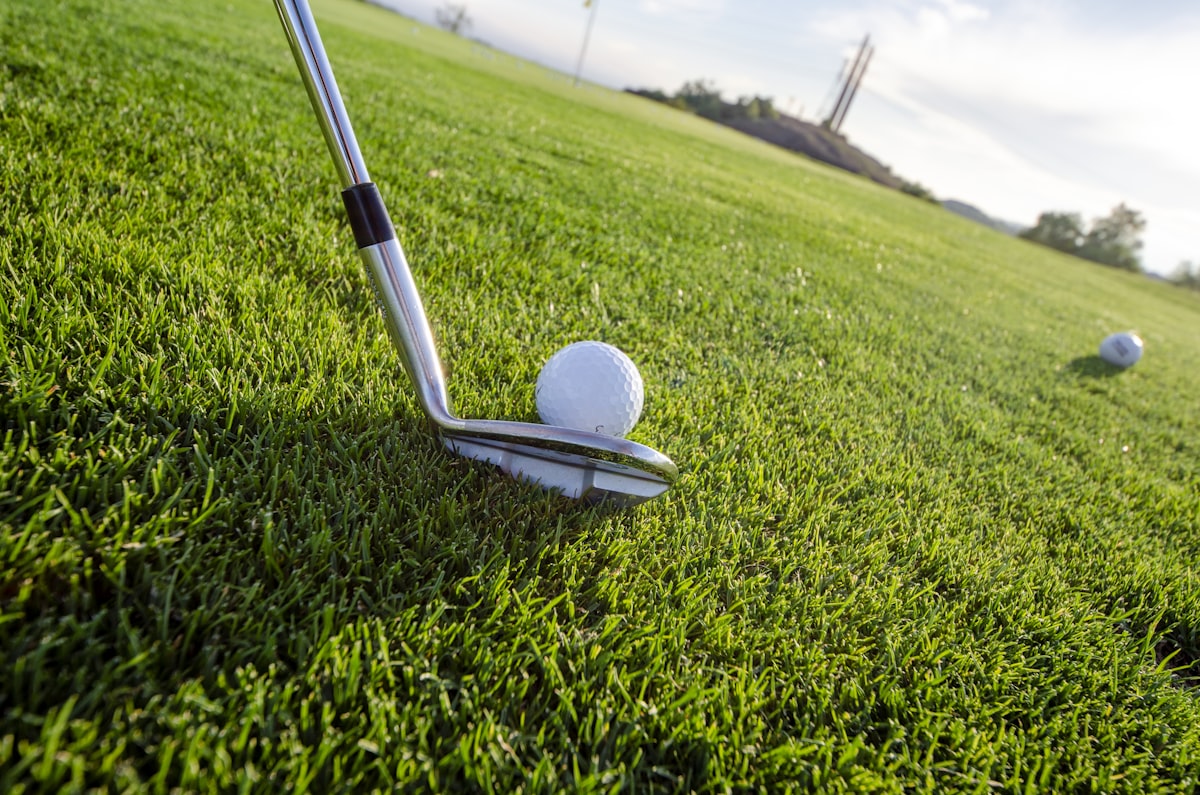 Golfer practicing at a driving range with lush green turf