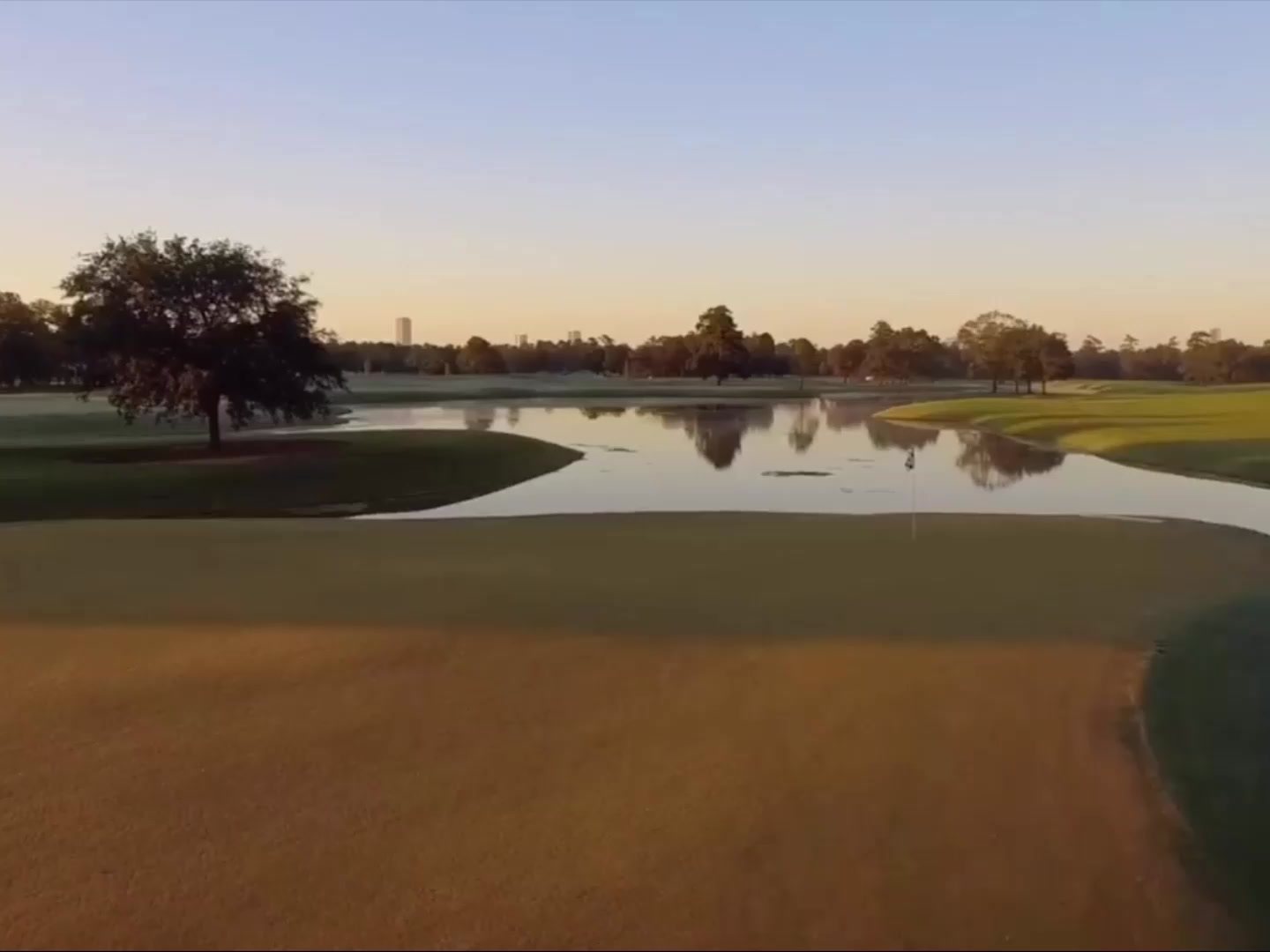 Sunrise over the water and a closely mown fairway at Memorial Park Golf Course, Houston