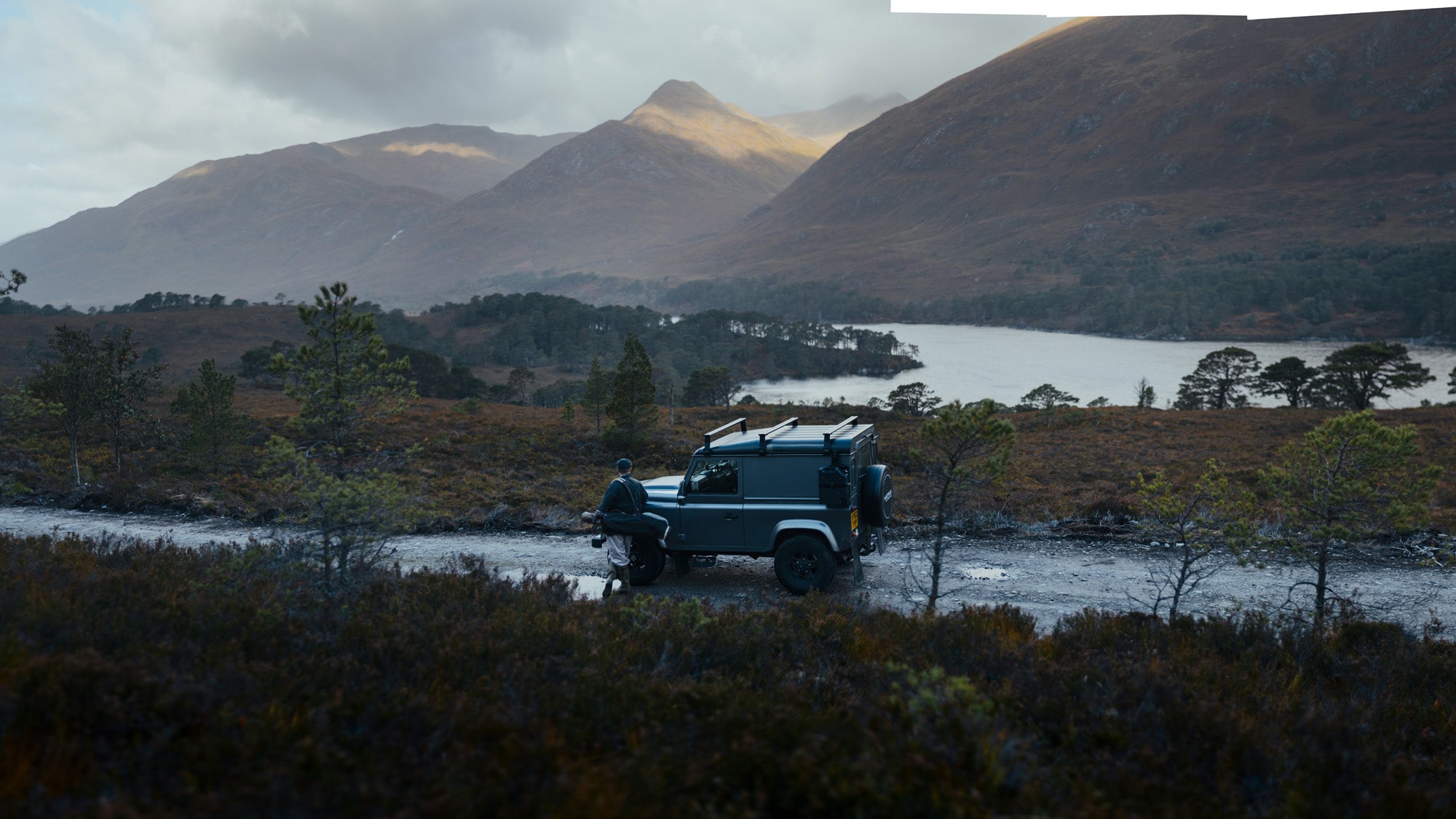 A Land Rover and a golfer on a hill road in Glen Affric, from the Shooters Club shoot