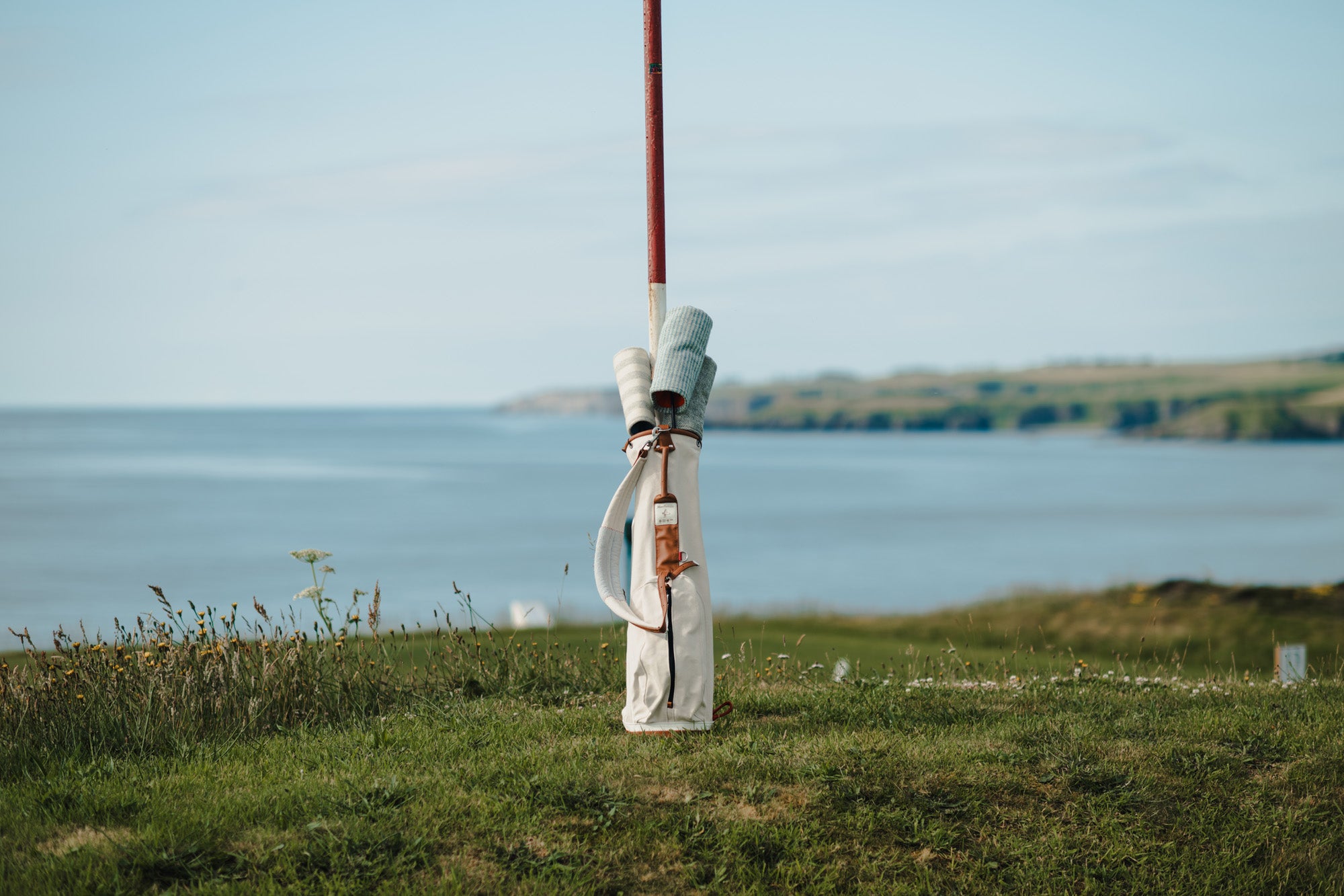 A MacKenzie x Fyfe bag resting against a marker pole, from the Summer Tweeds shoot