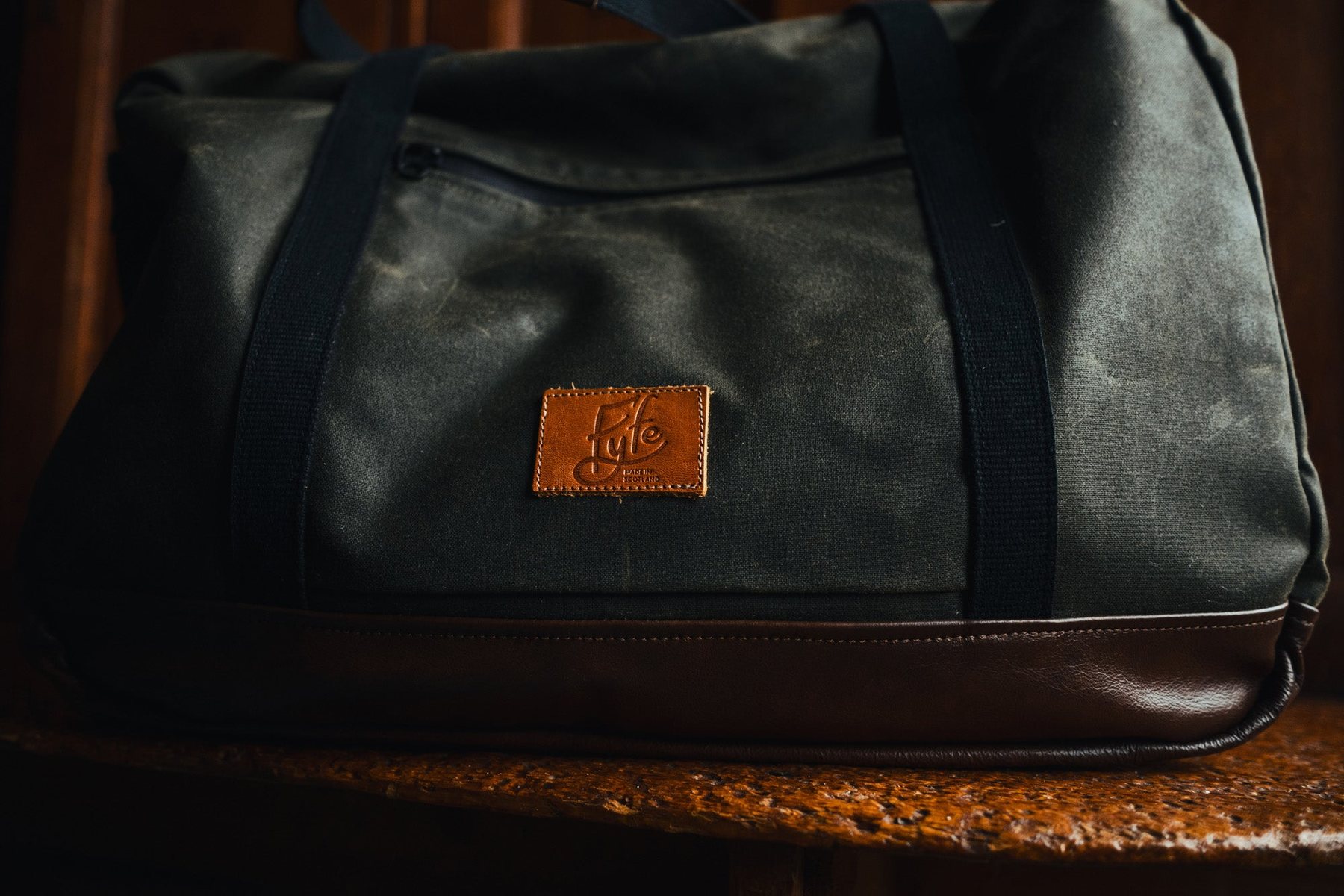 The Weekender bag on a wooden bench