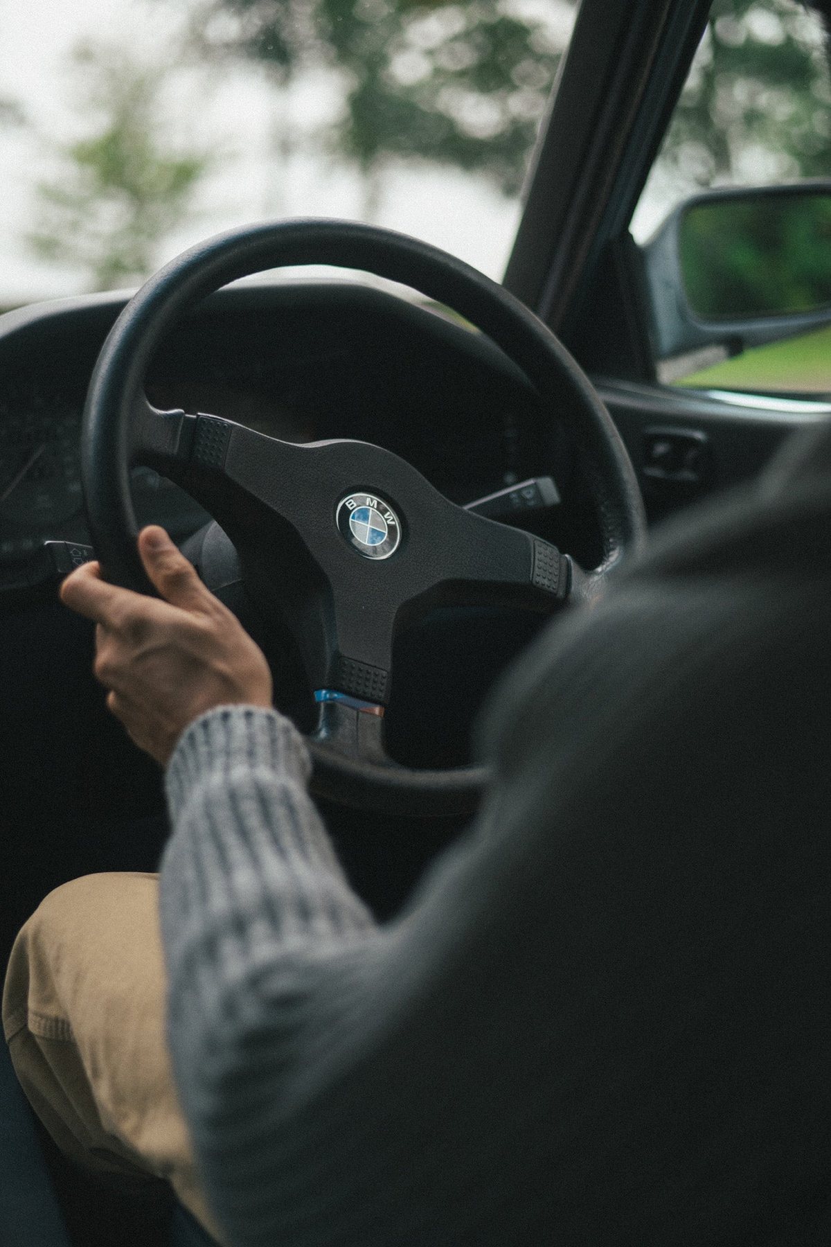 Hands on a wood-rimmed steering wheel