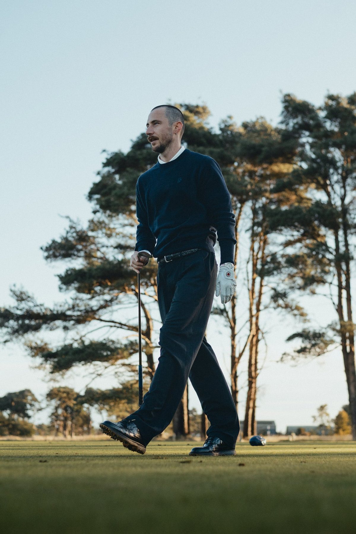 A golfer mid-stride on the fairway