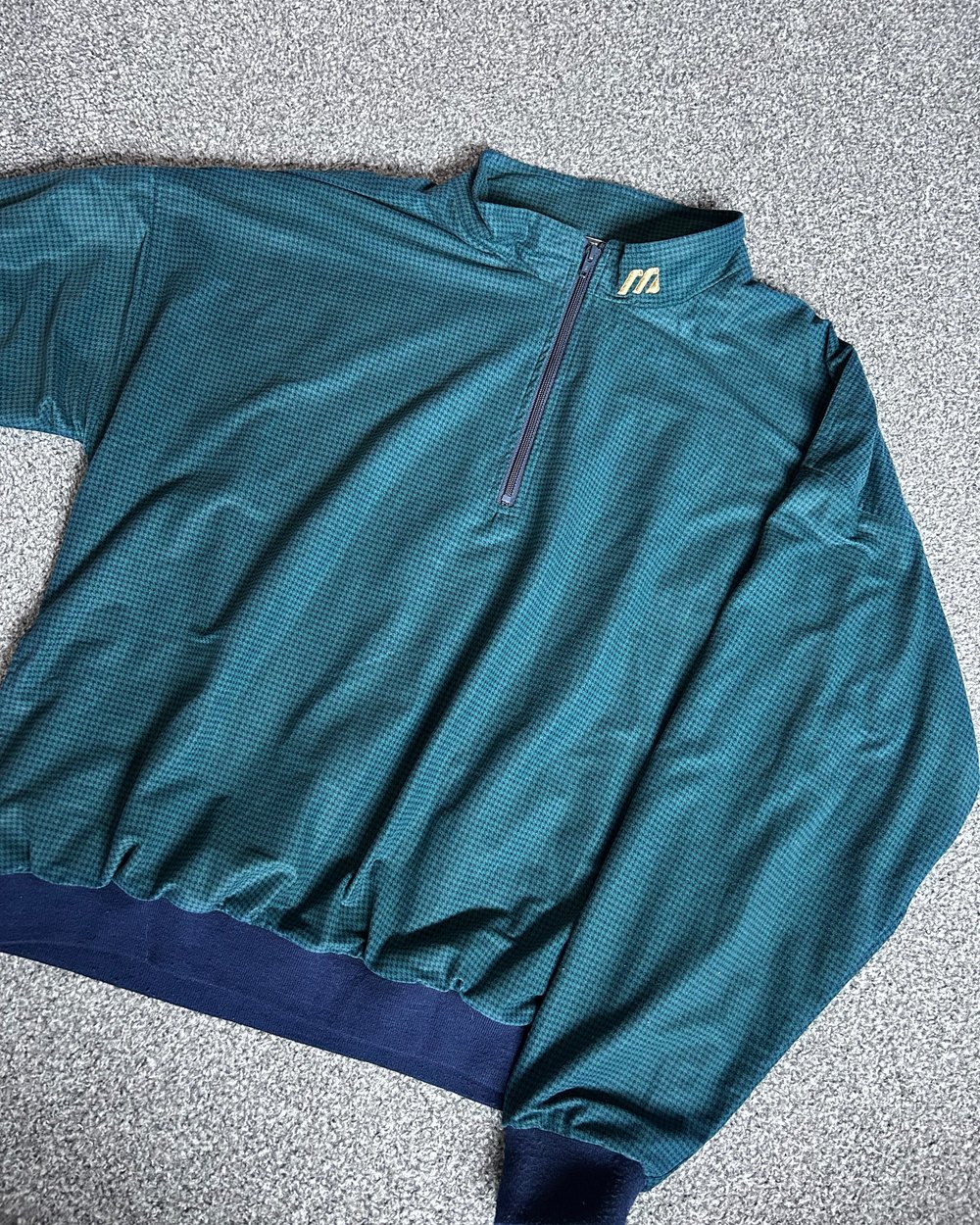 The original green Mizuno golf top, laid flat