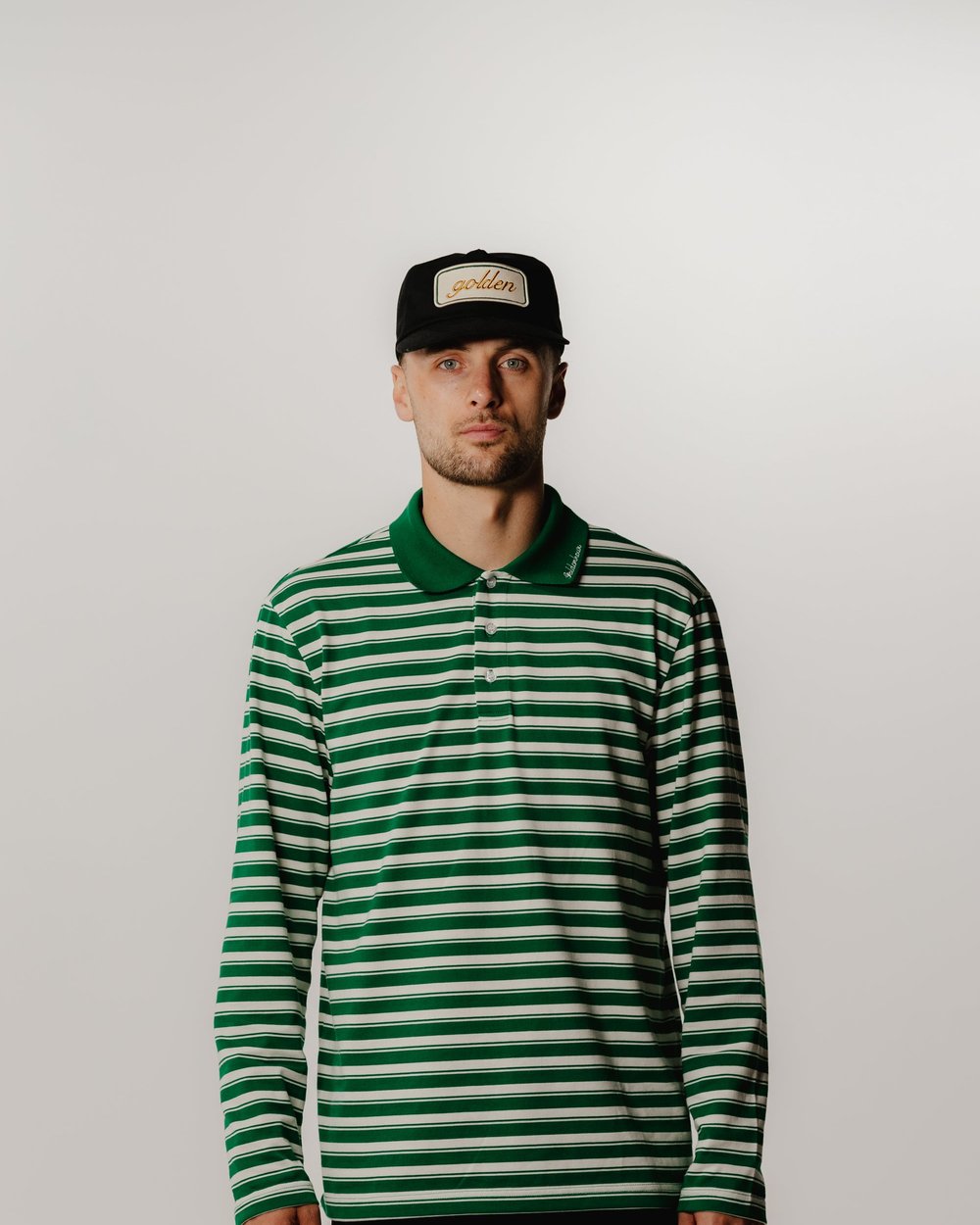 A golfer in a green and white striped long-sleeve polo