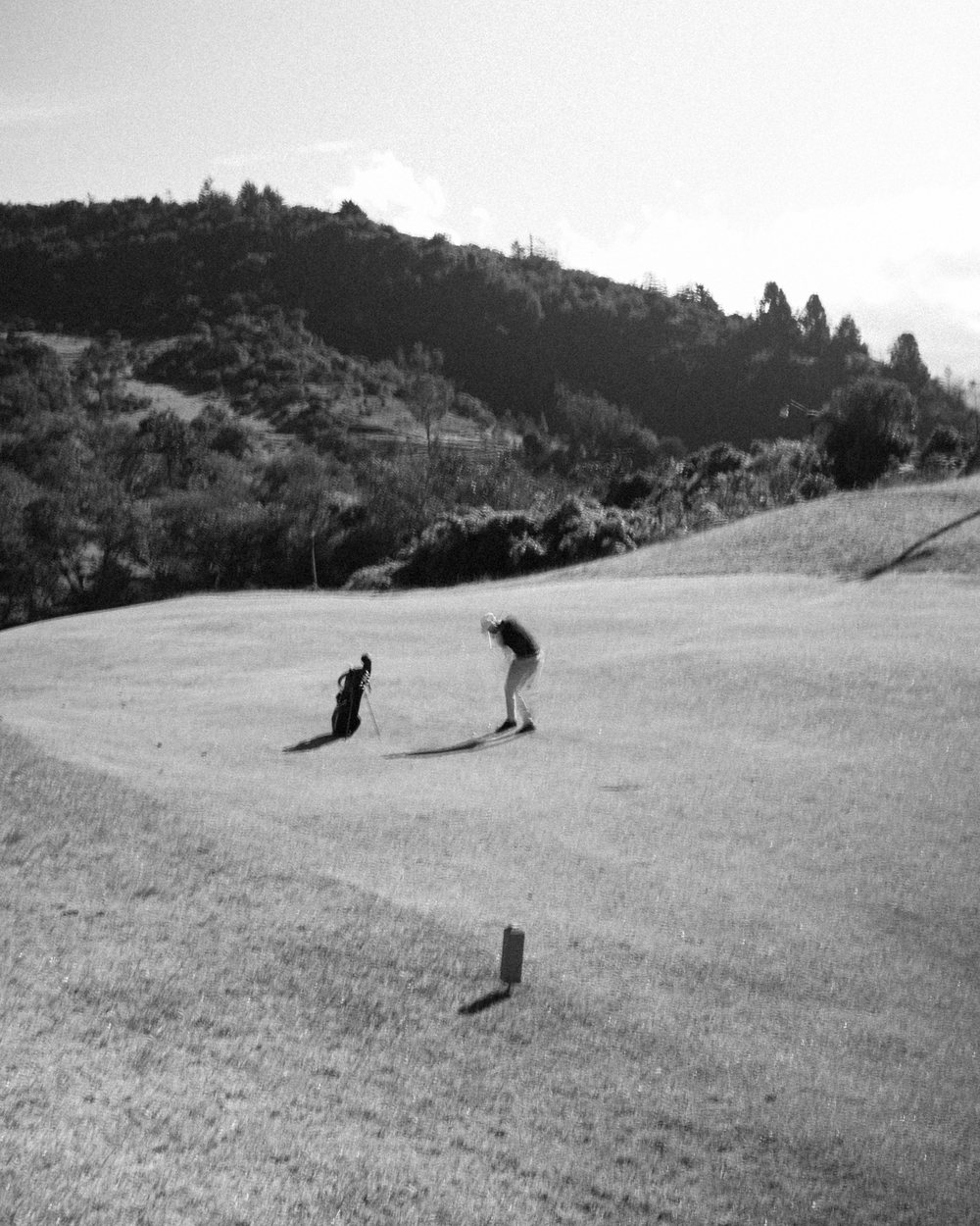 Golfers putting on a green in black and white