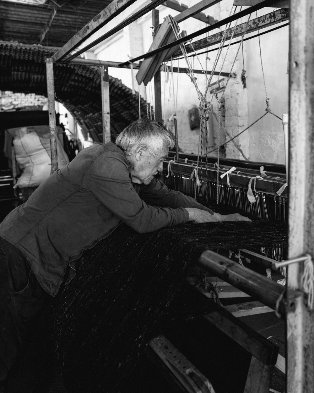A man working at a wooden loom