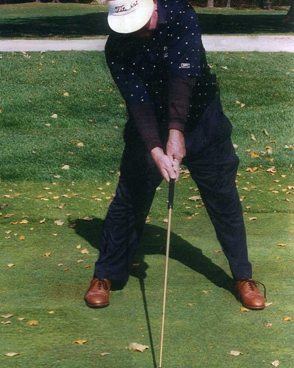 Moe Norman at address in a navy shirt and white visor