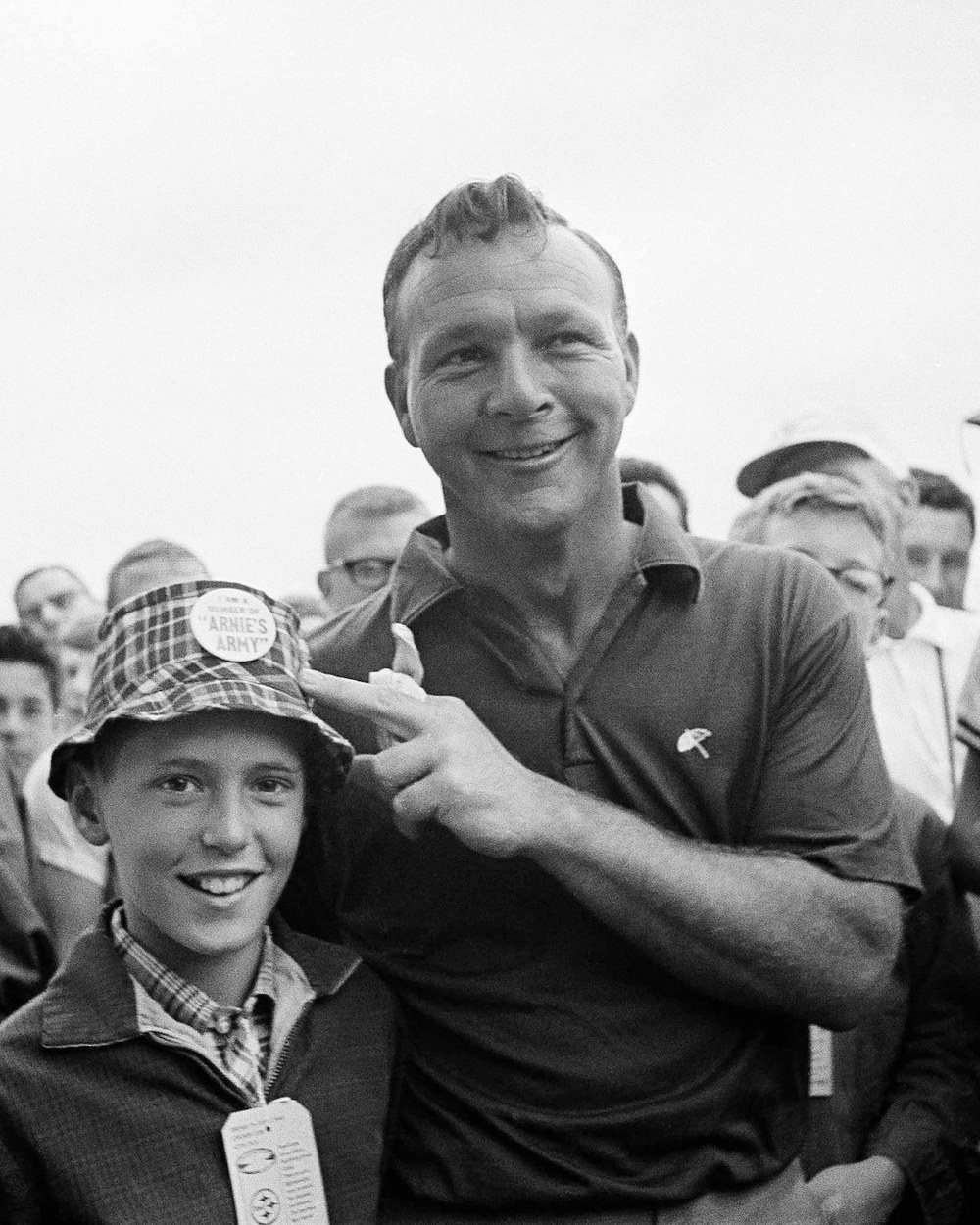 Arnold Palmer in a dark knit polo with young fans in the 1960s