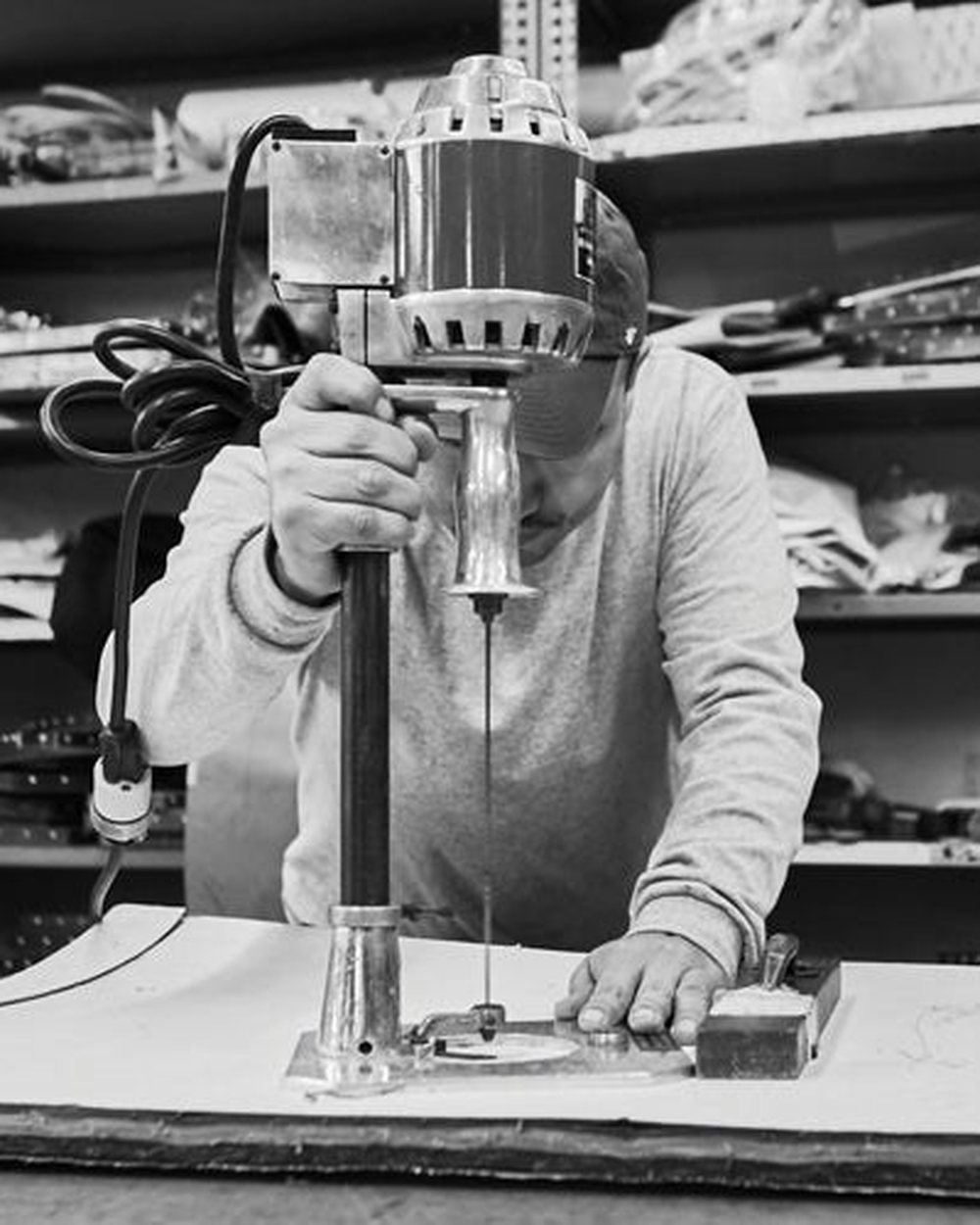 A Hudson Sutler worker cutting canvas with an industrial cutter