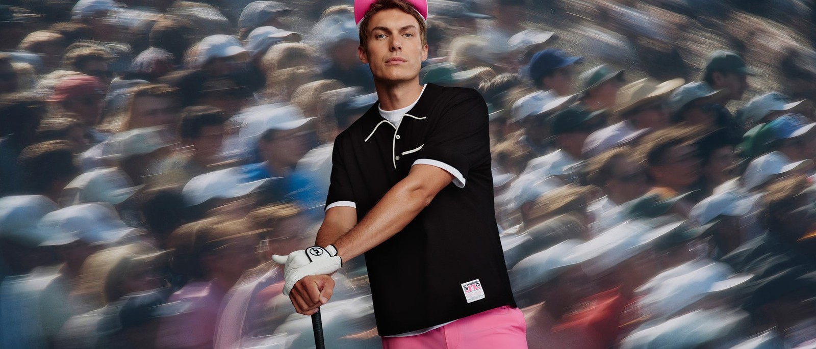 J.Lindeberg Pink Strategy campaign — pink cap and trousers against a blurred gallery