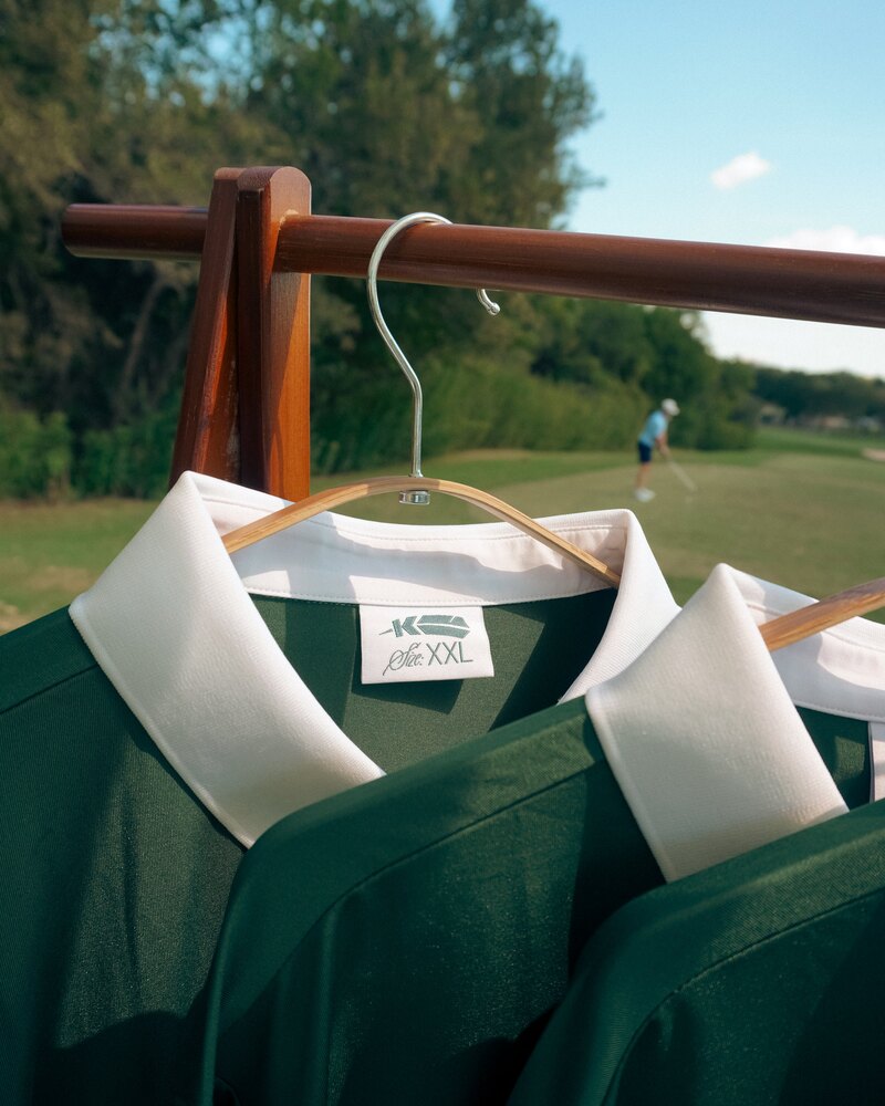 Kingfisher polos on a hanger with the course behind