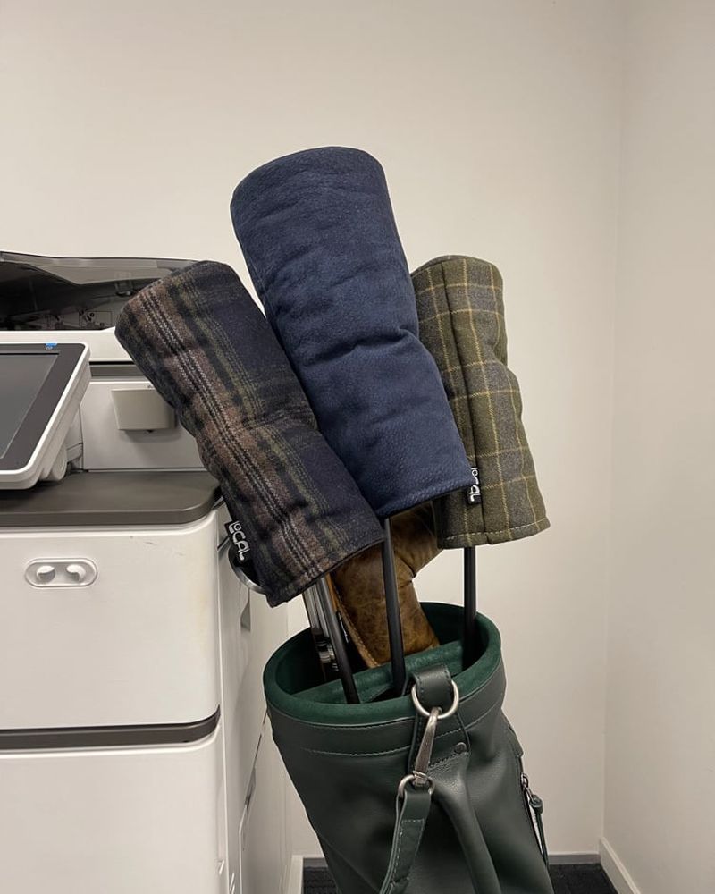 Check wool headcovers in a carry bag next to an office printer