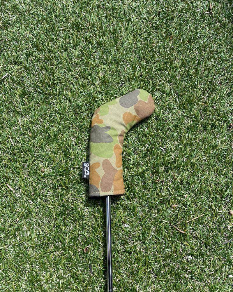 A camo canvas iron cover on a club on artificial turf